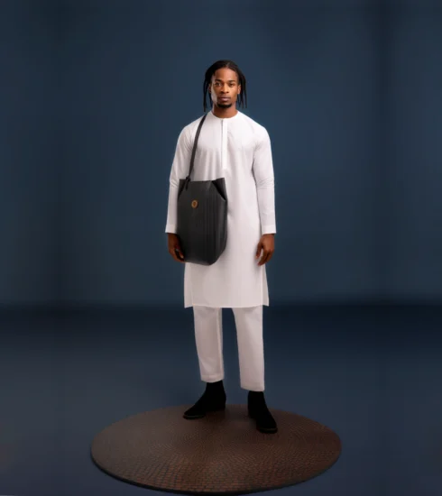 A Beautiful black male wearing a white plain kaftan dress with a placket and long sleeves made with a white cashmere fabric. Photo Credit: Akinlotan Olumide Oluseun